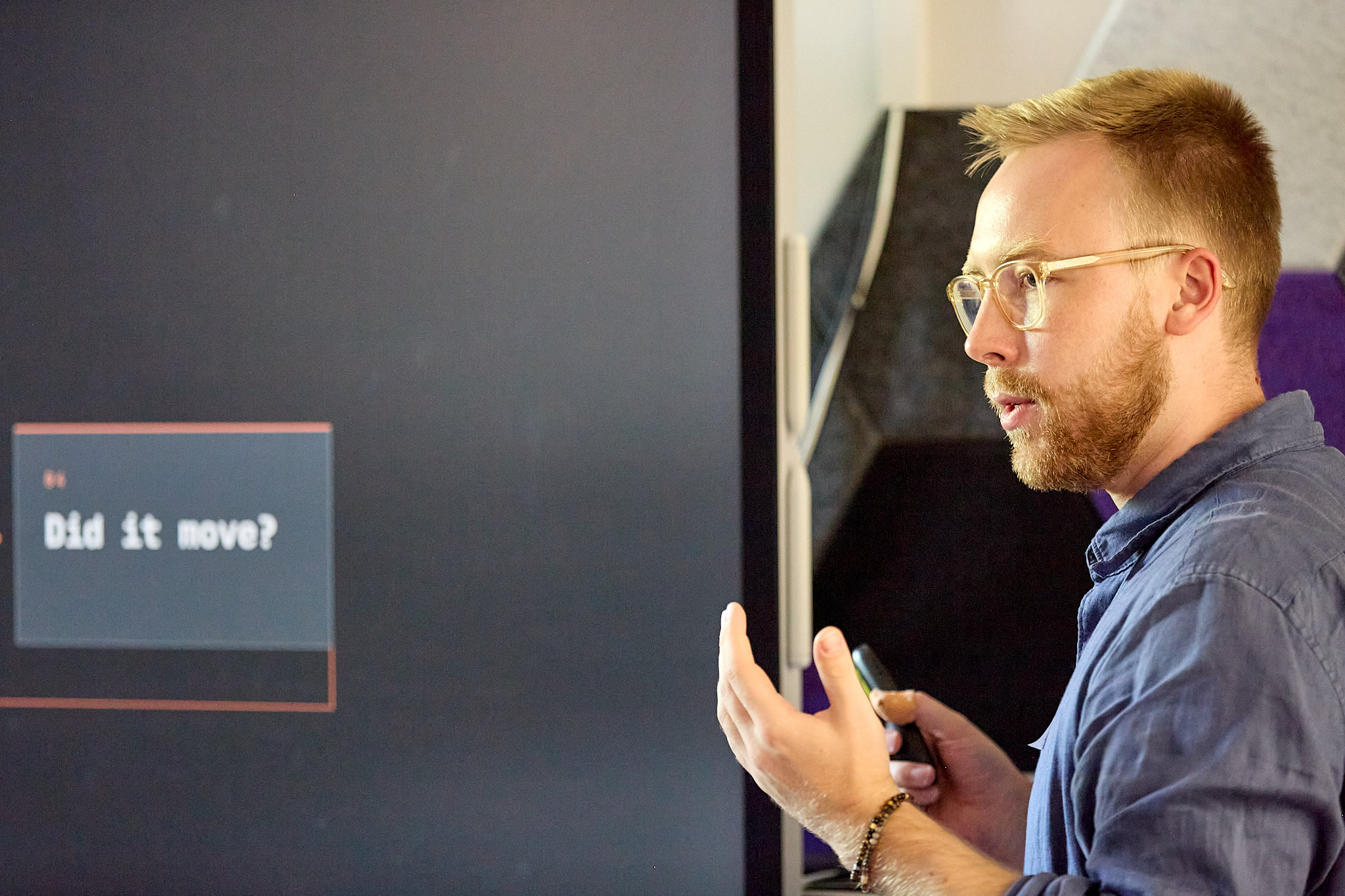 Luca Dombetzki presents at the planqc workshop, beside a slide reading 'Did it move?'